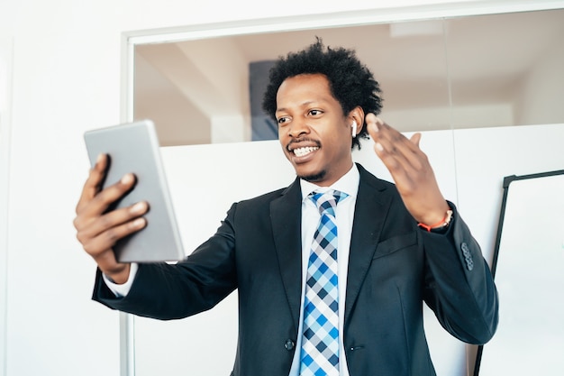 Professional businessman in a virtual meeting on video call with digital tablet at office