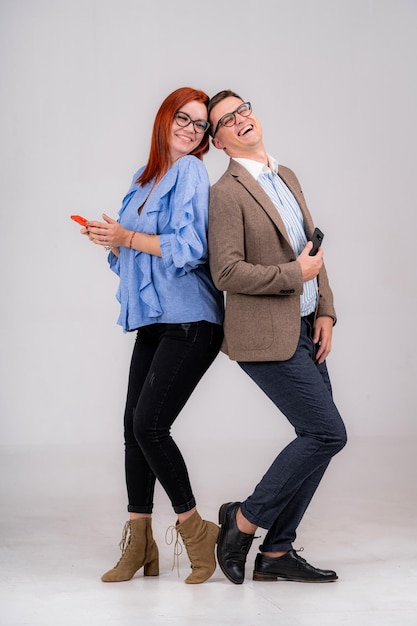 Профессиональный бизнесмен и женщина, стоящие за спиной в офисе, весело смеются Концепция партнерских отношений