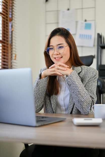 Professional businesswoman looking at her laptop screen planning her new strategy