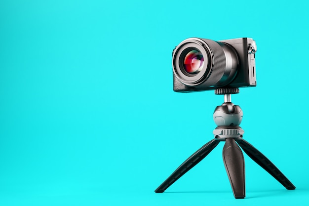 Professional camera on a tripod, on a blue background. record videos and photos for your blog or report