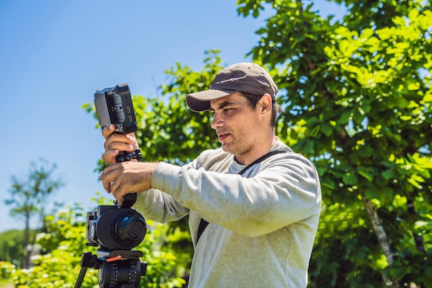 A professional cameraman prepares a camera and a tripod before shooting.