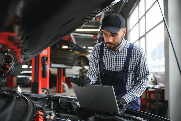 Foto meccanico professionista che lavora nel servizio di riparazione auto.