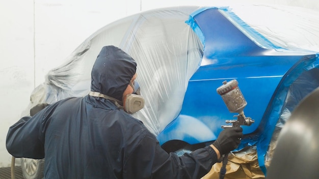 Photo professional car painter in vehicle workshop close up