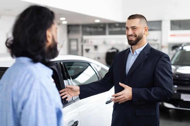 Фото Профессиональный продавец автомобилей разговаривает с клиентом