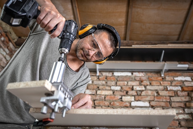 Professional carpenter working with wood and building tools in house.