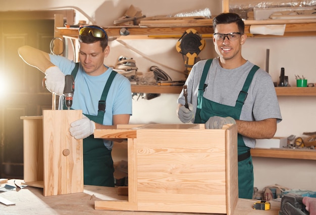 Carpentieri professionisti che assemblano armadietto in legno in officina