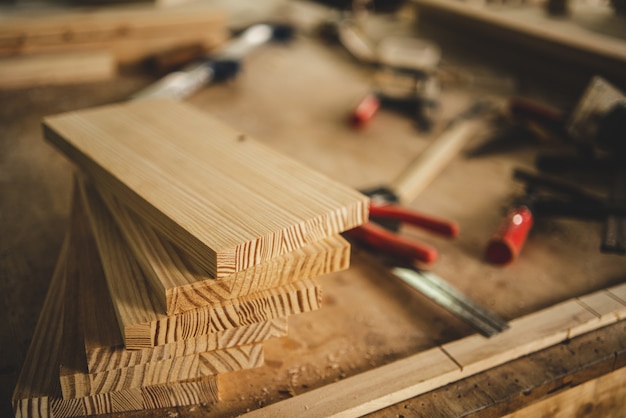 Фото Профессиональный столярный инструмент, оборудование для мастерских с деревообрабатывающей промышленностью, плотник, работающий в ремесленном строительстве из дерева, мастер и деревянная доска в столярной мастерской.