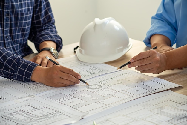 Professional cartographers working with cadastral map at table closeup