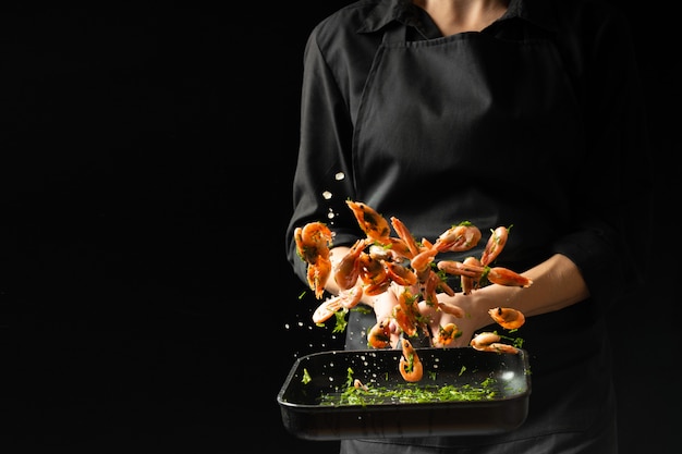 Gamberetti cucinati dal cuoco professionista. frutti di mare e cibo culinario su uno sfondo scuro.