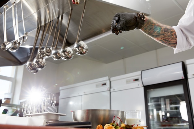 Foto chef professionista che cucina nella cucina moderna nel ristorante dell'hotel che prepara insalata di gamberetti