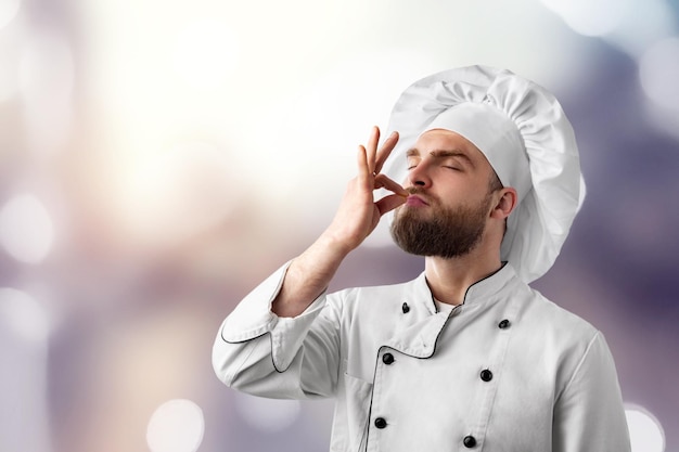 Chef professionista che mostra segno per delizioso. cuoco unico maschio in uniforme bianca con segno perfetto.