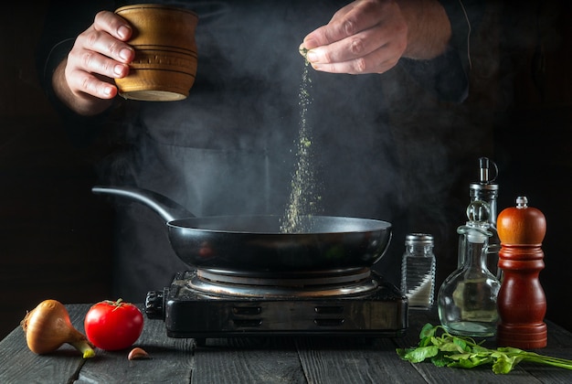 Professional chef pours spices into pan