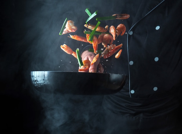 Professional chef prepares shrimp with herbs Cooking seafood