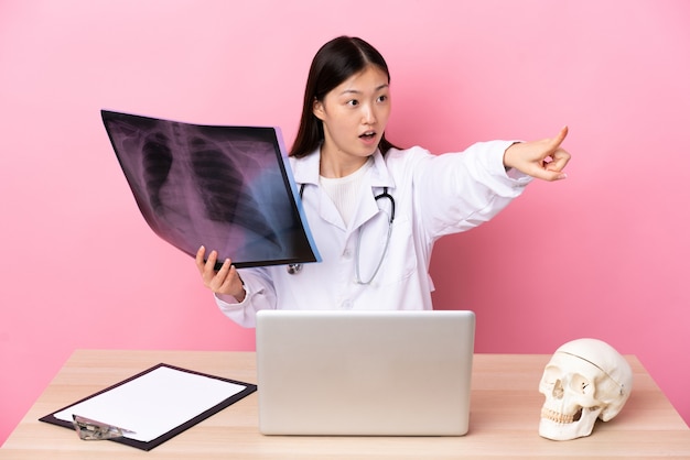 Профессиональный китайский травматолог на рабочем месте, указывая пальцем в сторону