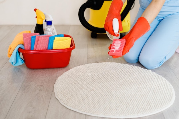 Professional cleaning at home woman in protective gloves using a detergent and a