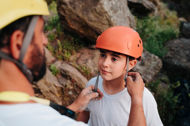 Professional climber preparing his student to be safe while climbing