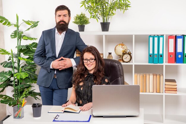 Professional and competent. Professional couple at work. Business professionals working in office. Man standing at woman at workplace. Potential made real.