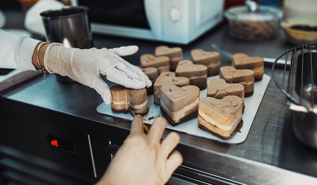 Professional confectioner working making and decorating delicious sweets.