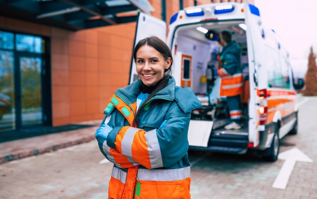 Photo professional and confident young woman doctor  with ambulance