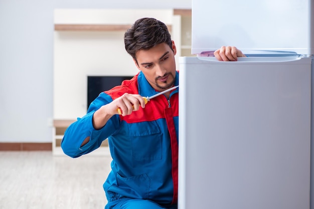 Professional contractor repairing broken fridge