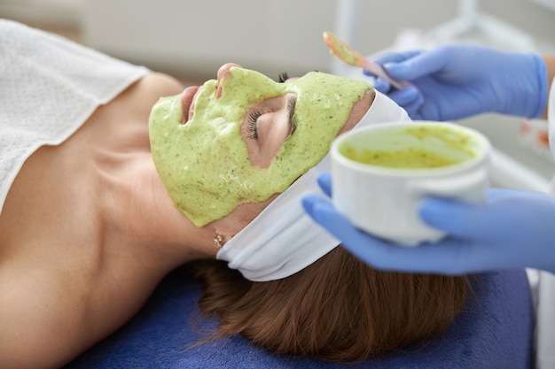 Photo professional cosmetologist is doing procedures for client in cabinet