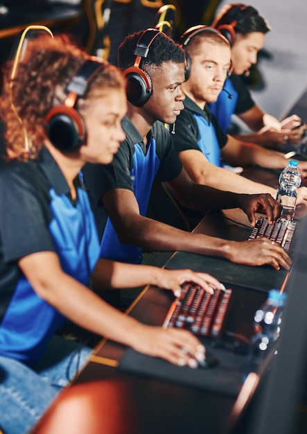 Professional cybersport team wearing headphones participating in esport tournament playing online