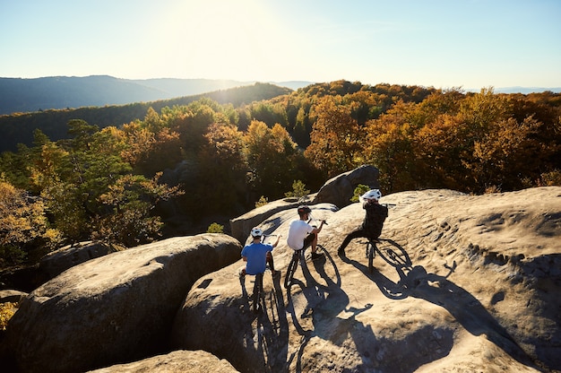 Professional cyclist balancing on trial bicycle at sunset