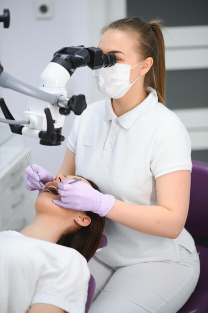 Professional dentist examination patient with microscope at the office