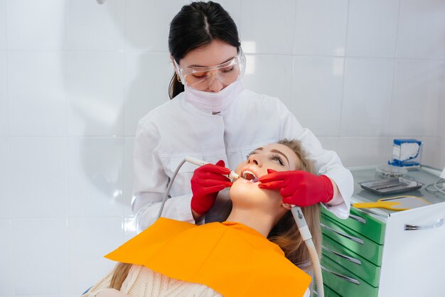 A professional dentist performs treatment and examination of the patient's oral cavity in close-up. Dentistry.