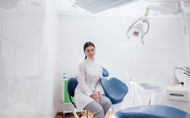 a professional dentist stands in a modern light dental office. dentistry.
