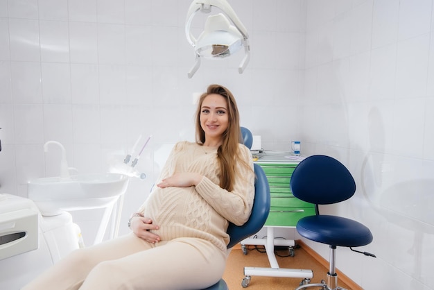 A professional dentist treats and examines the oral cavity of a pregnant girl in a modern dental office. Dentistry.