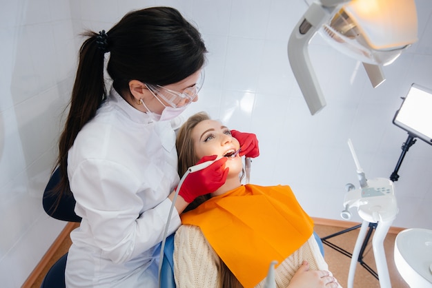 A professional dentist treats and examines the oral cavity of a pregnant woman in a modern dental office. Dentistry