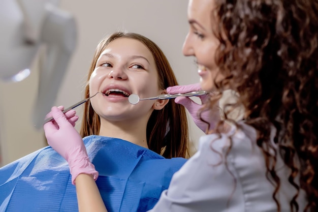 プロの歯科医が特殊な歯科用器具を使用して甘やかされて育った歯を検査し、治療します医療機器健康な歯のコンセプト