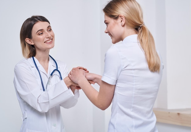 Professional doctor nurse shakes hands with a patient and a stethoscope around her neck High quality photo