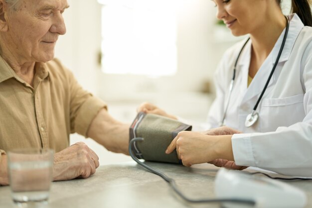 Foto medico professionista che si prepara a controllare la pressione sanguigna dell'uomo anziano