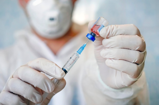 Professional doctor with medical syringe in hands, getting ready for injection. Medical concept. Mass vaccination against seasonal diseases, influenza, covid 19, corona viruses,