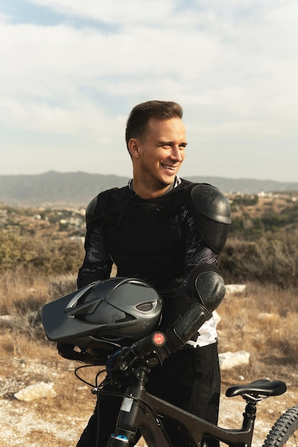 Professional downhill rider fully equipped with protective gear and his bicycle