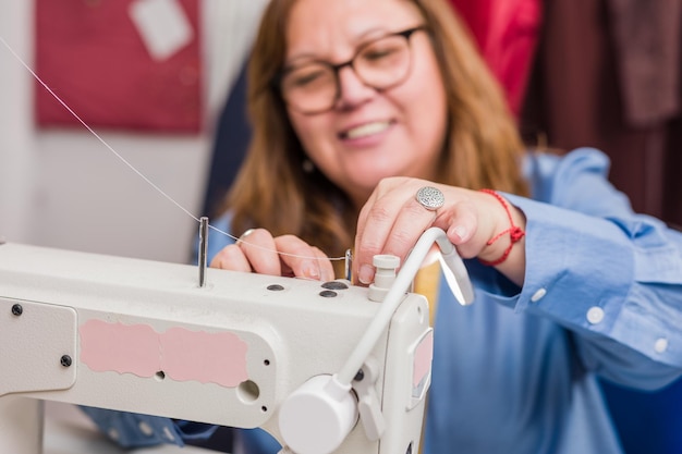 Professional dressmaker doing sustainable ecofriendly slow fashion Cheerful hispanic chilean woman