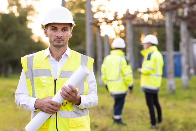 Professional electrical industry engineer smiling and looking at the camera  workers wearing safety