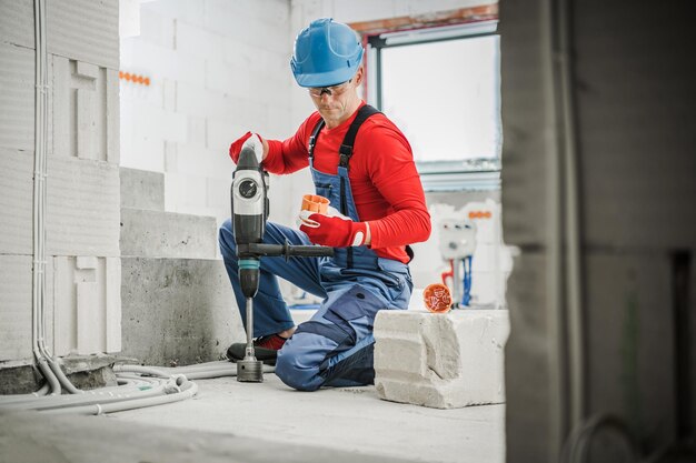 Professional electrician with hole saw during work