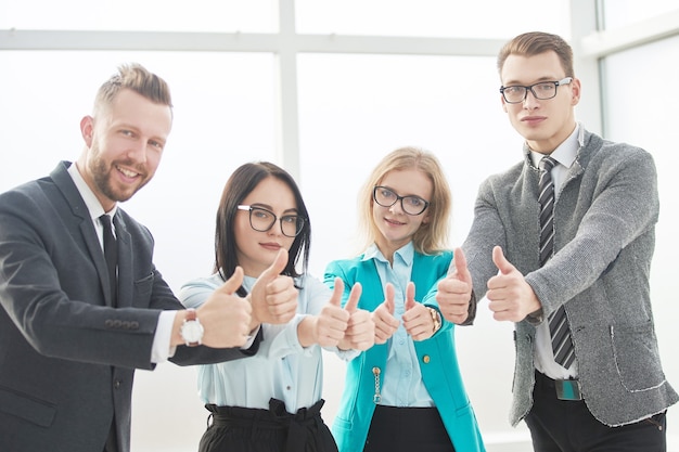 Professional employees of the company showing thumbs up