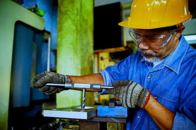 Operatore tecnico uomo ingegnere professionista ispezione del concetto di manutenzione della macchina per macchine operatrici in fabbrica