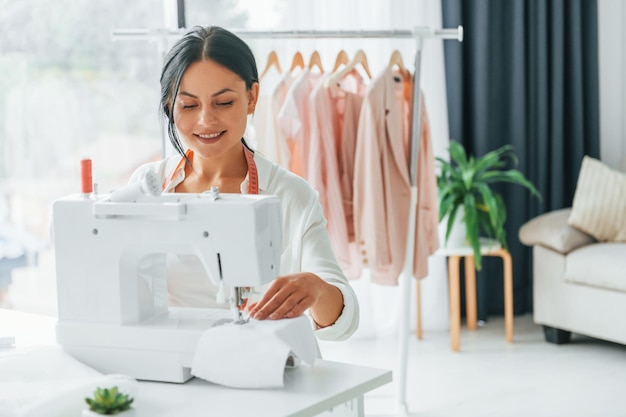 プロの機器仕立て屋は、別の服を着ている彼女のオフィスにいます