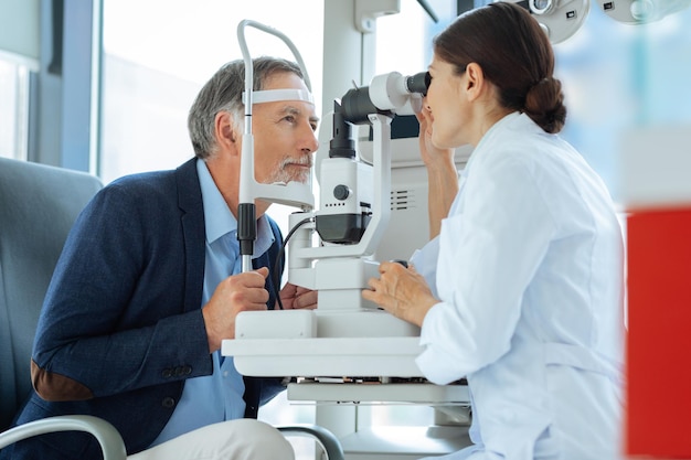 Professional eye doctor sitting opposite her patient