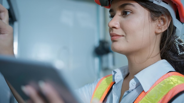 Professional factory manager checking and controlling machine at factory