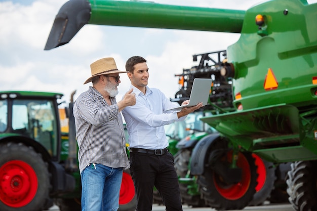 Agricoltore professionista con una moderna mietitrebbia sul campo alla luce del sole al lavoro