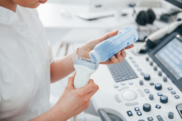 Photo professional female clinic worker in white coat is indoors in the cabinet