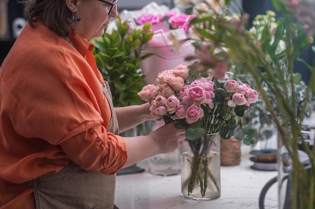 전문 여성 플로리스트가 멋진 혼합 꽃 부케를 준비합니다.