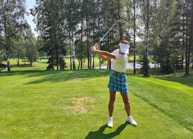 Professional female golfer in sportswear plays golf at golf practice tournament on course