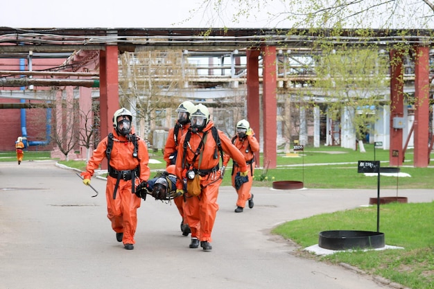 Professional firefighters rescuers in orange protective fireresistant suits white helmets